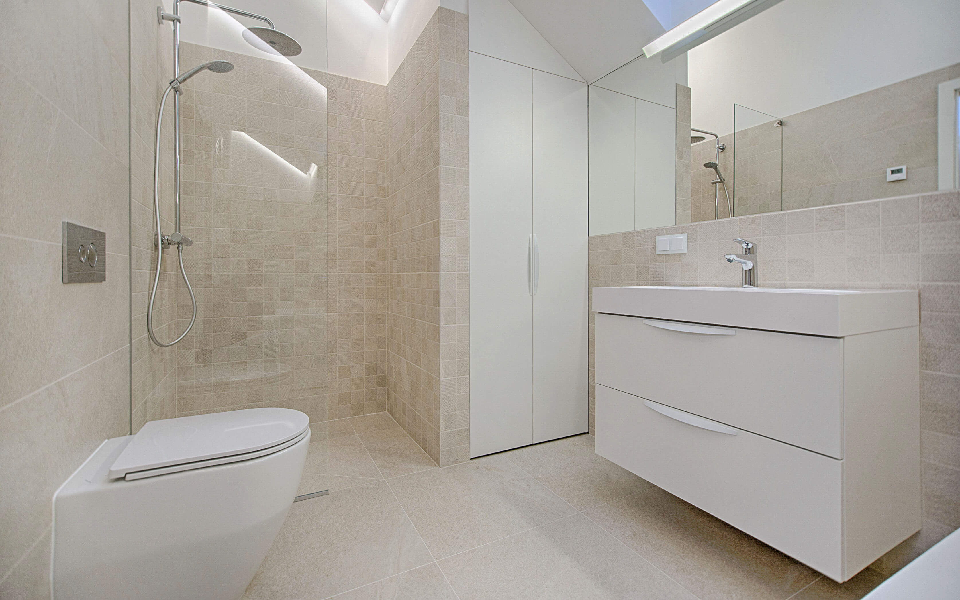 Small sand colored bathroom with a compact toilet, built in linnen closet and floating vanity